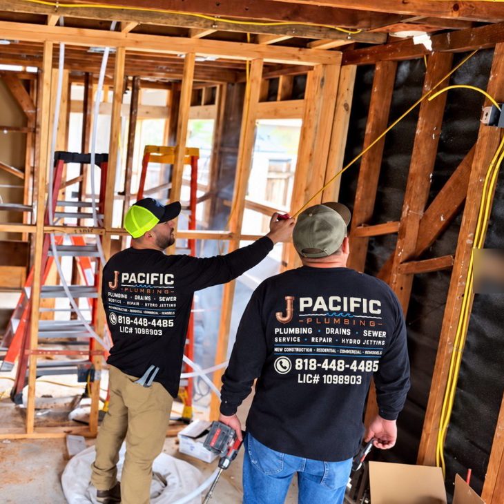 J Pacific Plumbing crew in company shirts measuring during a remodel rough-in